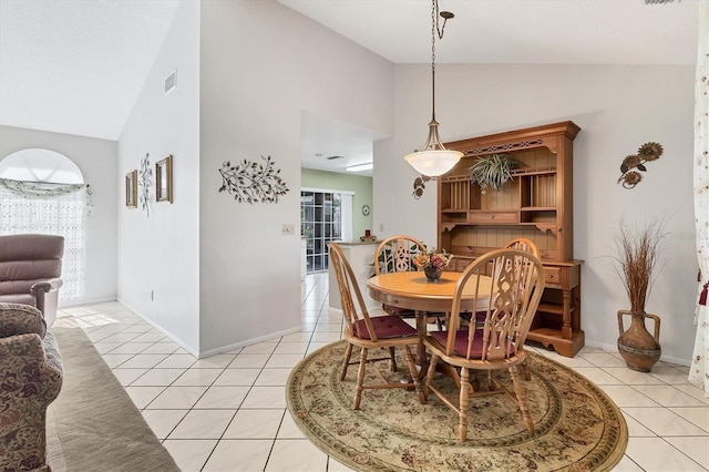 dining area with light tile patterned floors and high vaulted ceiling