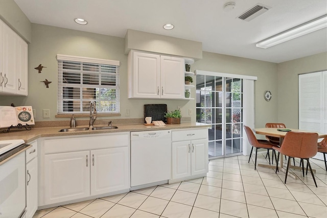 kitchen with white appliances, light tile patterned floors, sink, and white cabinets