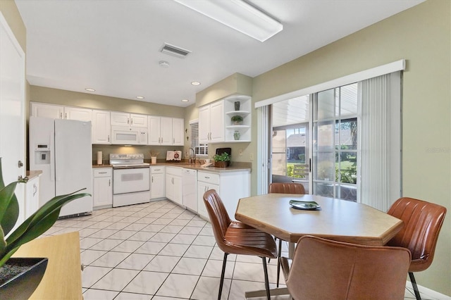 kitchen featuring light tile patterned floors, white appliances, sink, and white cabinets