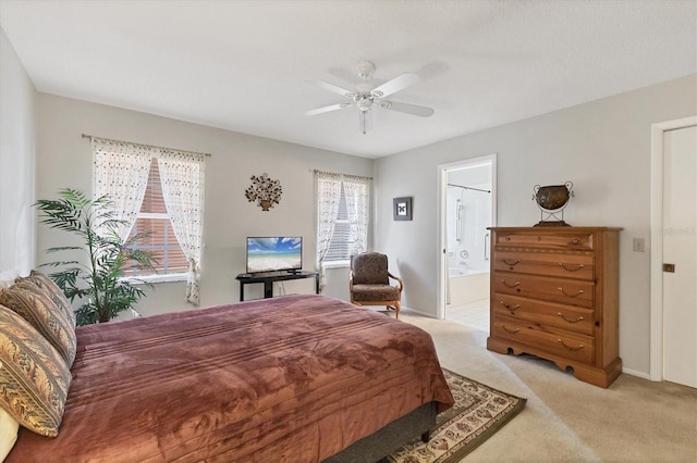 bedroom featuring ceiling fan, ensuite bathroom, and light carpet