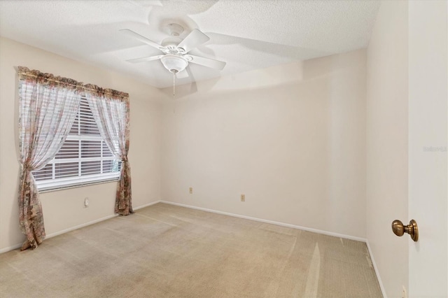 carpeted empty room featuring ceiling fan and a textured ceiling