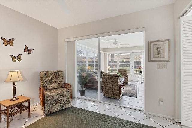 living area with light tile patterned floors and ceiling fan