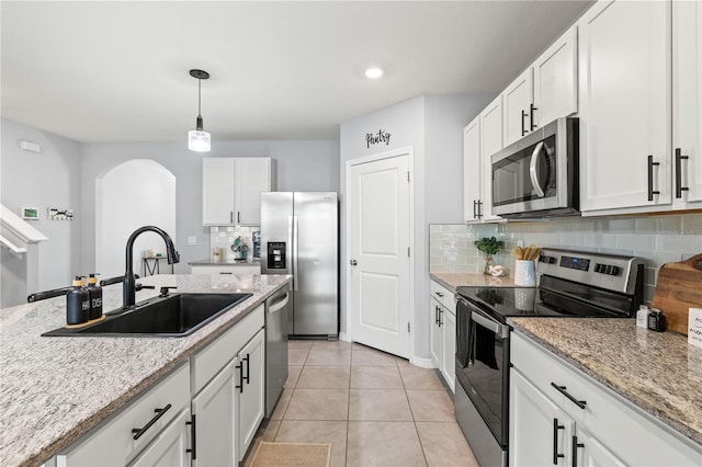 kitchen featuring white cabinetry, sink, light stone countertops, and appliances with stainless steel finishes