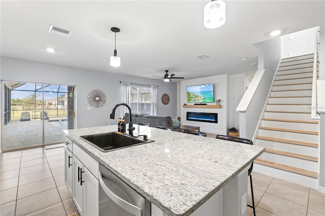 kitchen featuring sink, white cabinetry, dishwasher, an island with sink, and pendant lighting