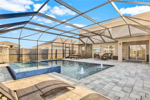 view of pool with an in ground hot tub, pool water feature, a patio, and glass enclosure