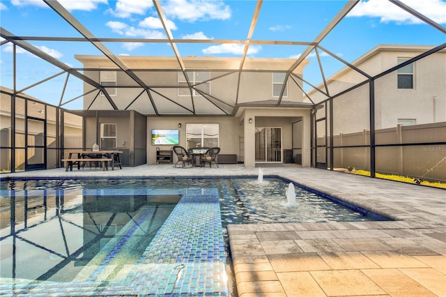 view of swimming pool featuring glass enclosure and a patio area