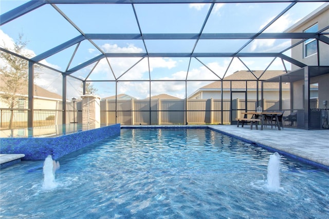 view of pool featuring pool water feature, a patio area, and glass enclosure