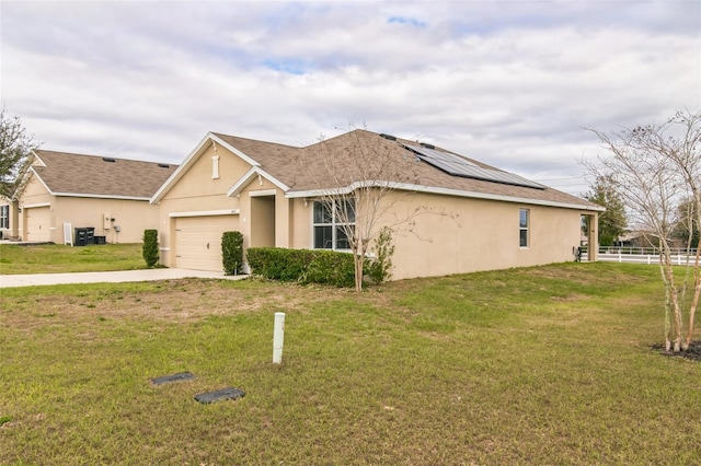 view of front of home featuring a garage, driveway, fence, a front yard, and stucco siding