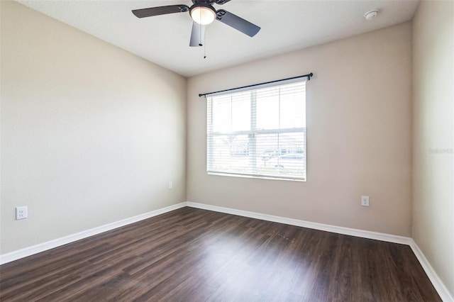 empty room featuring dark wood-style floors, ceiling fan, and baseboards