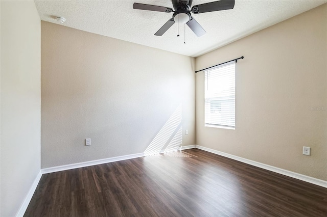 unfurnished room with ceiling fan, baseboards, dark wood finished floors, and a textured ceiling