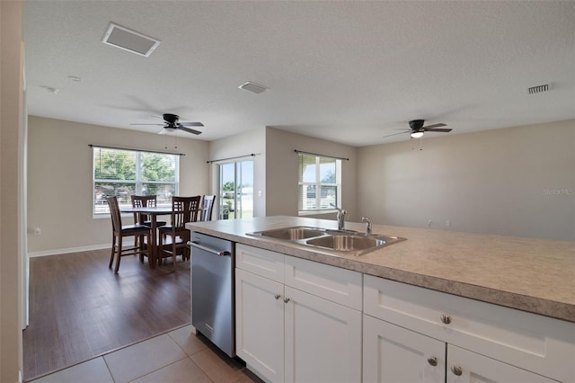 kitchen with visible vents, white cabinets, a sink, and light countertops