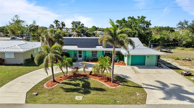 view of front facade featuring a garage, a front lawn, and solar panels