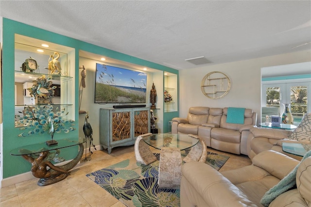 living room with light tile patterned floors, french doors, and a textured ceiling