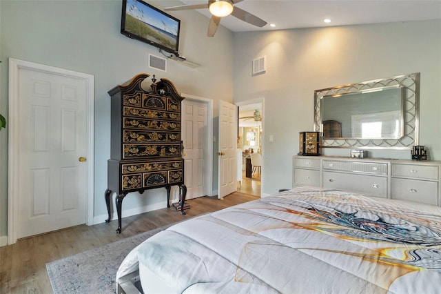 bedroom with light hardwood / wood-style flooring, high vaulted ceiling, and ceiling fan