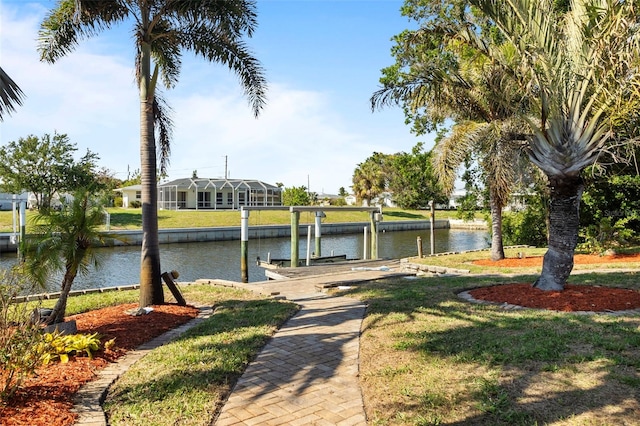 view of dock with a water view and a lawn