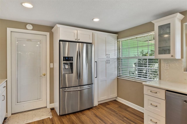 kitchen featuring white cabinetry, stainless steel appliances, dark hardwood / wood-style flooring, and a textured ceiling