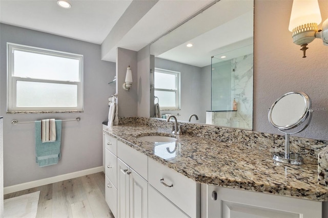 bathroom featuring hardwood / wood-style flooring, vanity, and a shower