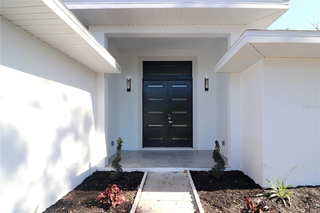 doorway to property featuring stucco siding