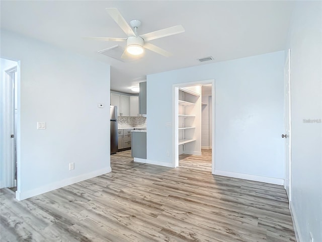 empty room with ceiling fan and light wood-type flooring