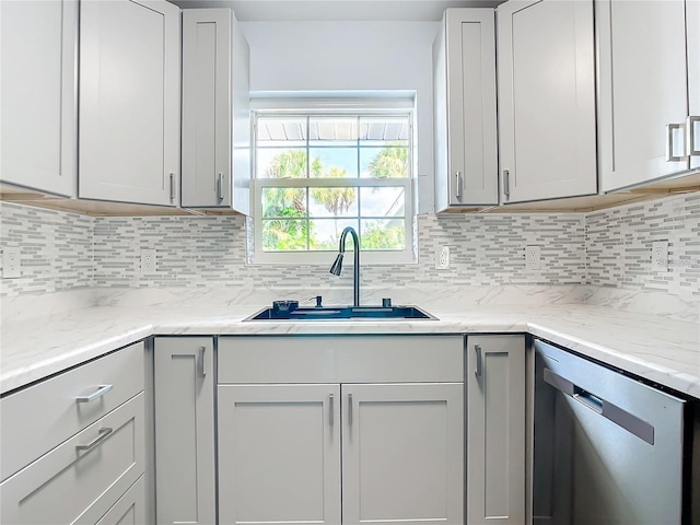 kitchen featuring sink, decorative backsplash, stainless steel dishwasher, and light stone countertops