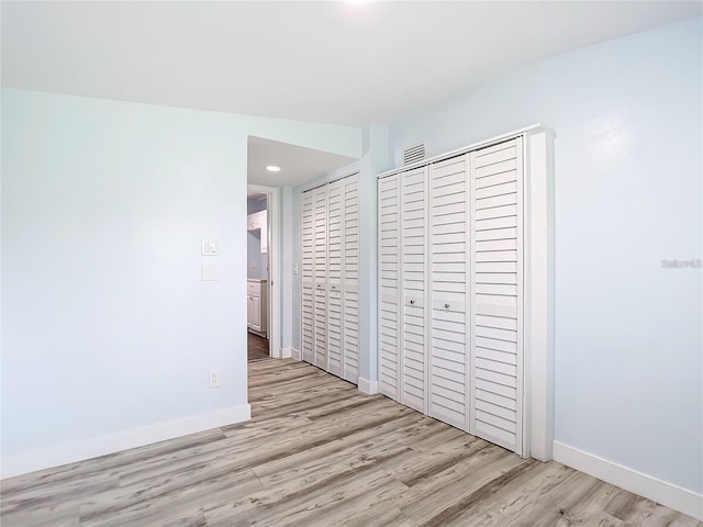 unfurnished bedroom featuring light wood-type flooring and a closet