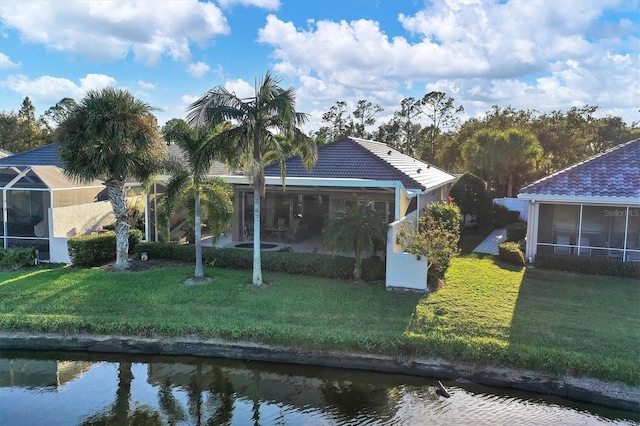 back of property featuring a water view, a yard, and a sunroom