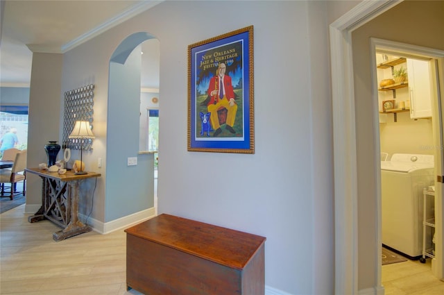 hall featuring crown molding, separate washer and dryer, and light hardwood / wood-style flooring