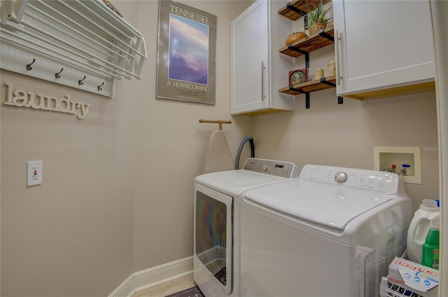 clothes washing area featuring washer and clothes dryer and cabinets