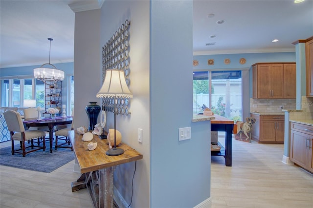 hallway with crown molding, plenty of natural light, and light hardwood / wood-style flooring