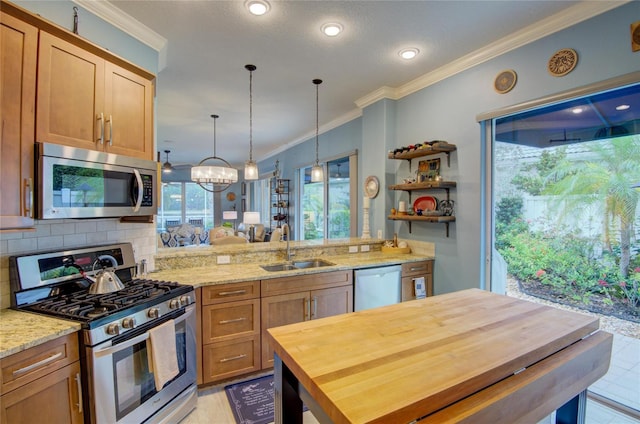 kitchen featuring sink, wooden counters, appliances with stainless steel finishes, pendant lighting, and decorative backsplash