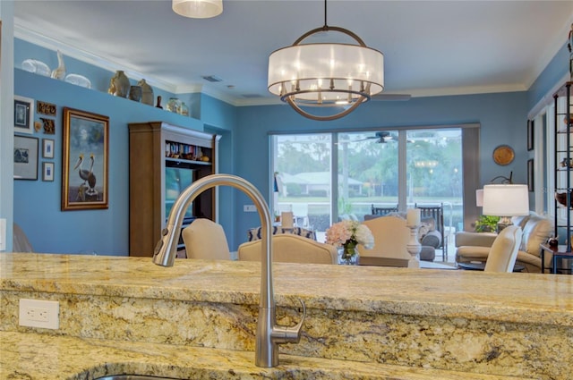 kitchen with hanging light fixtures, crown molding, sink, and a chandelier