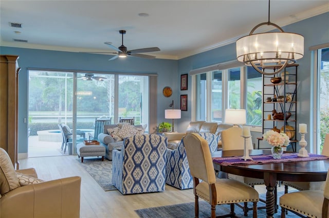 living room with a wealth of natural light, ornamental molding, and light wood-type flooring