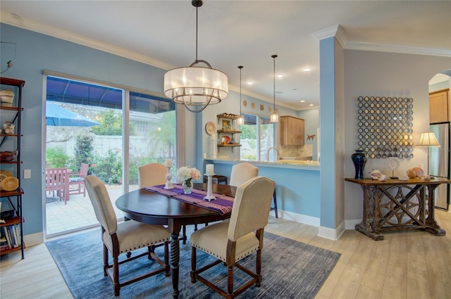 dining space featuring crown molding and light wood-type flooring