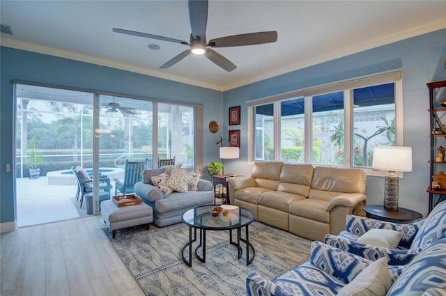 living room with crown molding, plenty of natural light, and light hardwood / wood-style flooring