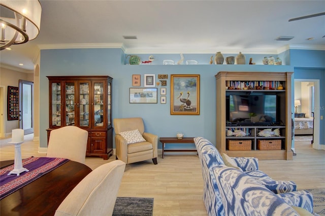 living room featuring an inviting chandelier, light hardwood / wood-style flooring, and ornamental molding