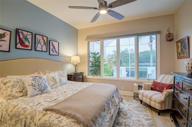 bedroom featuring multiple windows, light hardwood / wood-style floors, and ceiling fan