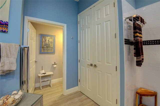 bathroom with a tile shower and hardwood / wood-style floors