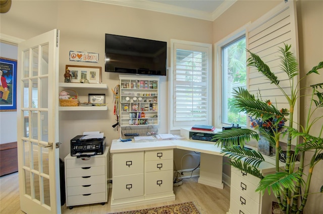 office space featuring french doors, ornamental molding, a healthy amount of sunlight, and light hardwood / wood-style flooring