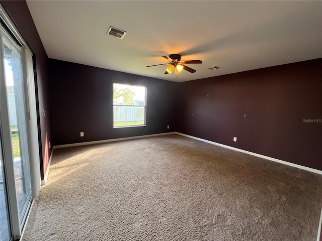 carpeted spare room with ceiling fan