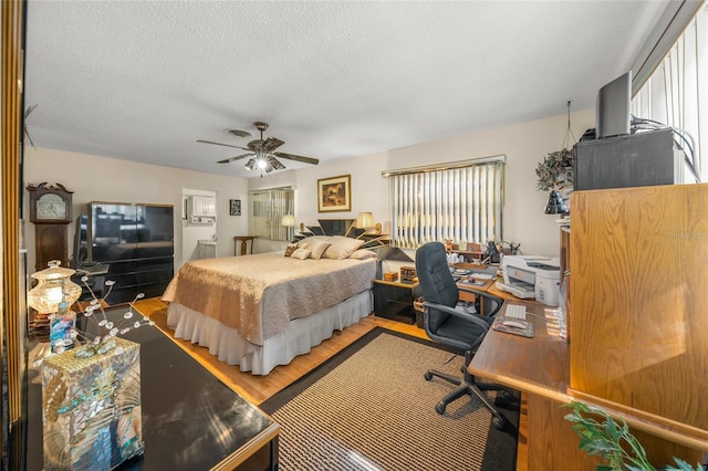 bedroom featuring a textured ceiling, visible vents, wood finished floors, and a ceiling fan