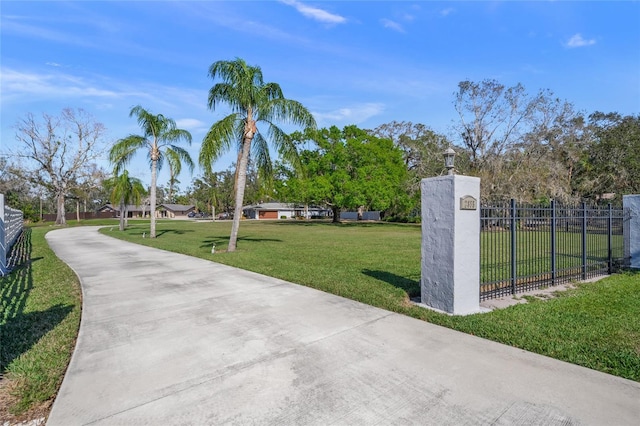 view of property's community with a yard and fence