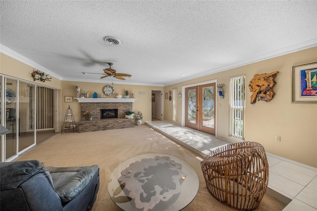 living area featuring ornamental molding, french doors, a fireplace, and visible vents