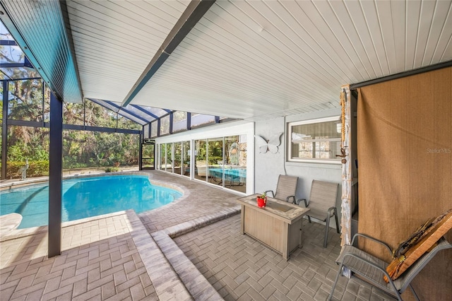 pool featuring glass enclosure and a patio