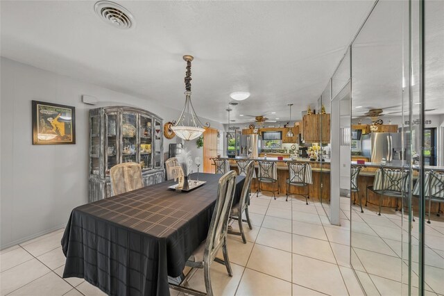 dining room with light tile patterned floors, visible vents, and a ceiling fan