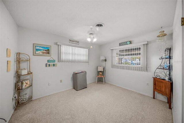 miscellaneous room featuring baseboards, visible vents, and light colored carpet