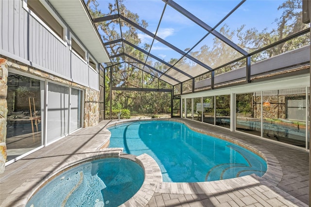 view of swimming pool featuring a lanai, a patio area, and a pool with connected hot tub