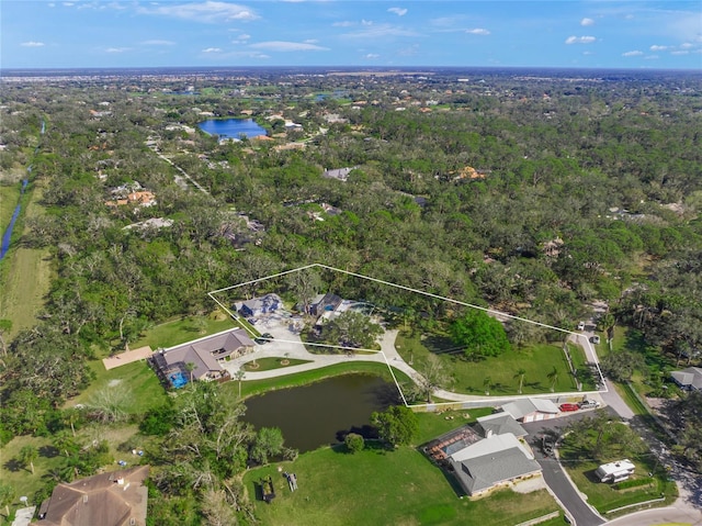 drone / aerial view featuring a water view and a wooded view