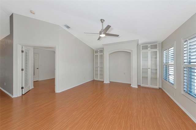 spare room featuring lofted ceiling, built in features, ceiling fan, and light hardwood / wood-style flooring