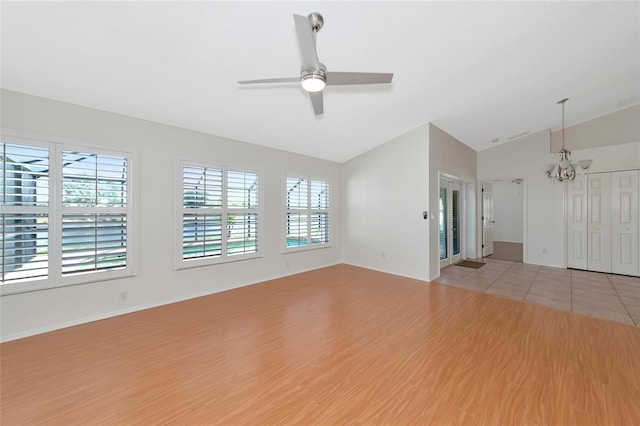 unfurnished living room featuring lofted ceiling, ceiling fan with notable chandelier, and light hardwood / wood-style floors