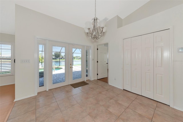 interior space with a water view, a wealth of natural light, light tile patterned floors, and french doors